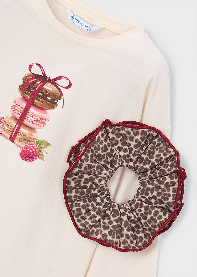 Leopard print scrunchie on a white background with a sweatshirt and macaron illustration.