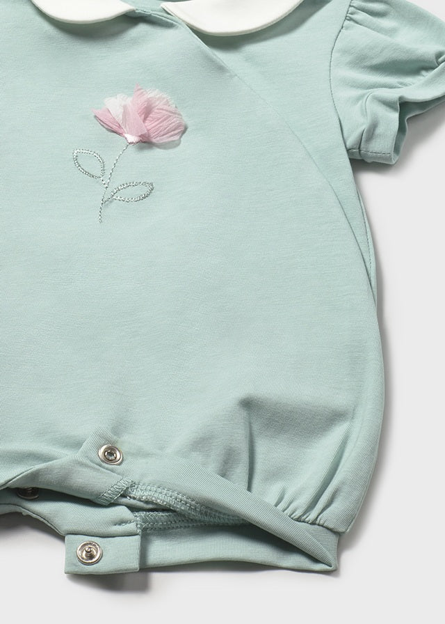Light blue baby romper with pink flower design on a white background