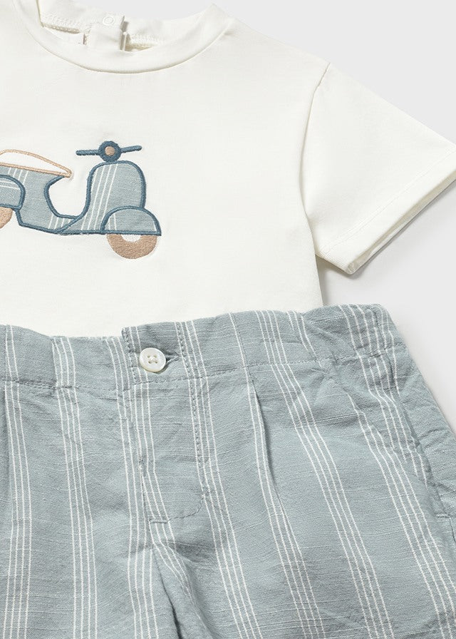 White shirt with scooter design and plaid shorts on a white background