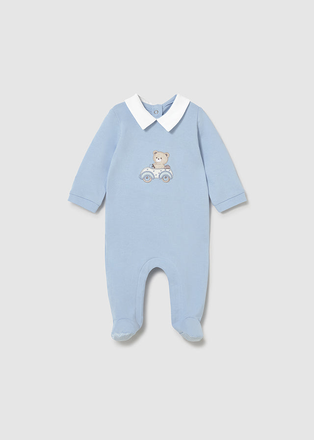 Blue baby onesie with a teddy bear design on a light gray background