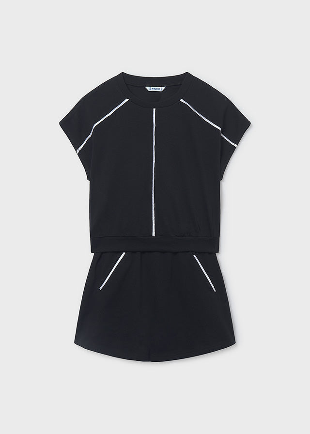 Black outfit with white accents on a light gray background