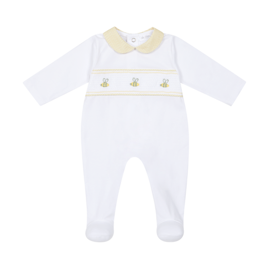 White baby onesie with yellow trim and embroidered details on a white background