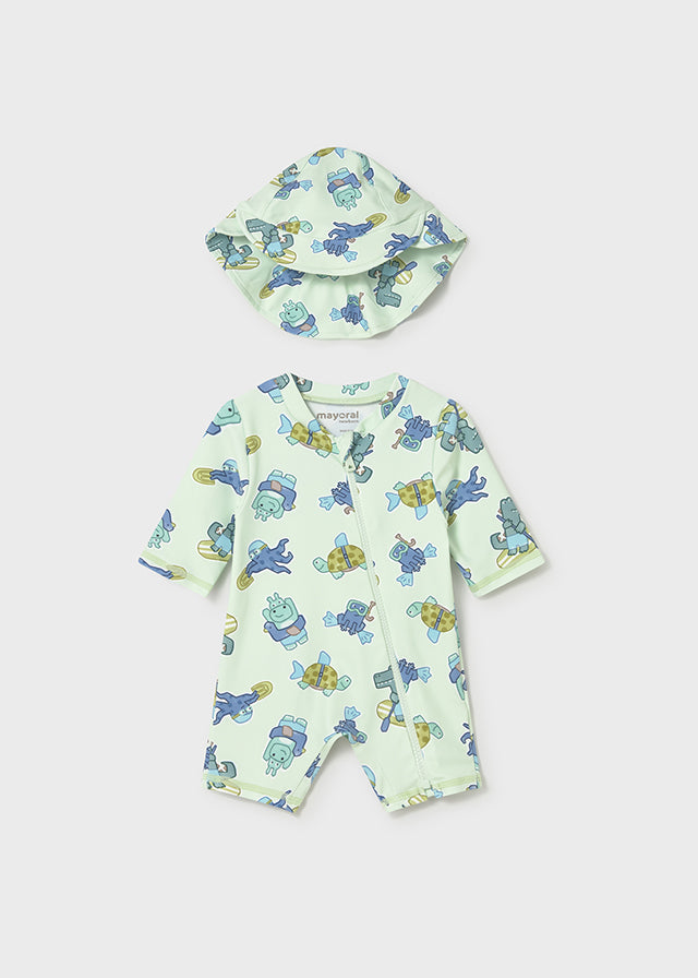 Baby swimsuit and hat set with turtle pattern on a light green background